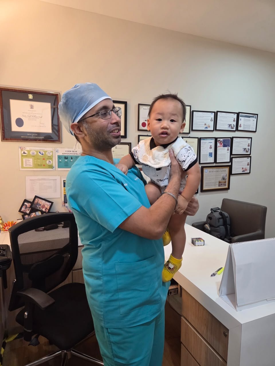 Dr Jasdev Singh with a baby in the clinic