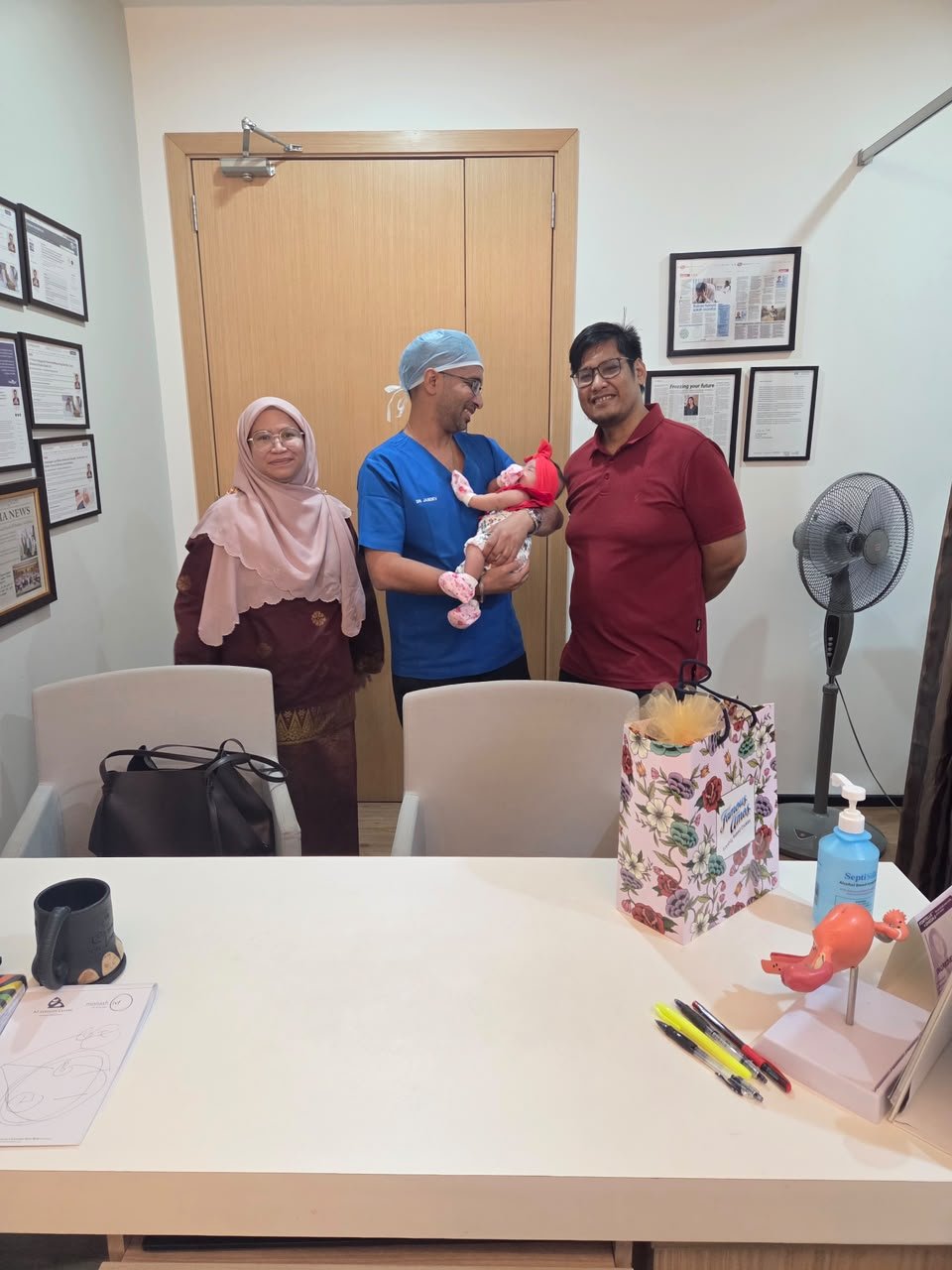 Dr Jasdev Singh with parents and newborn after consultation