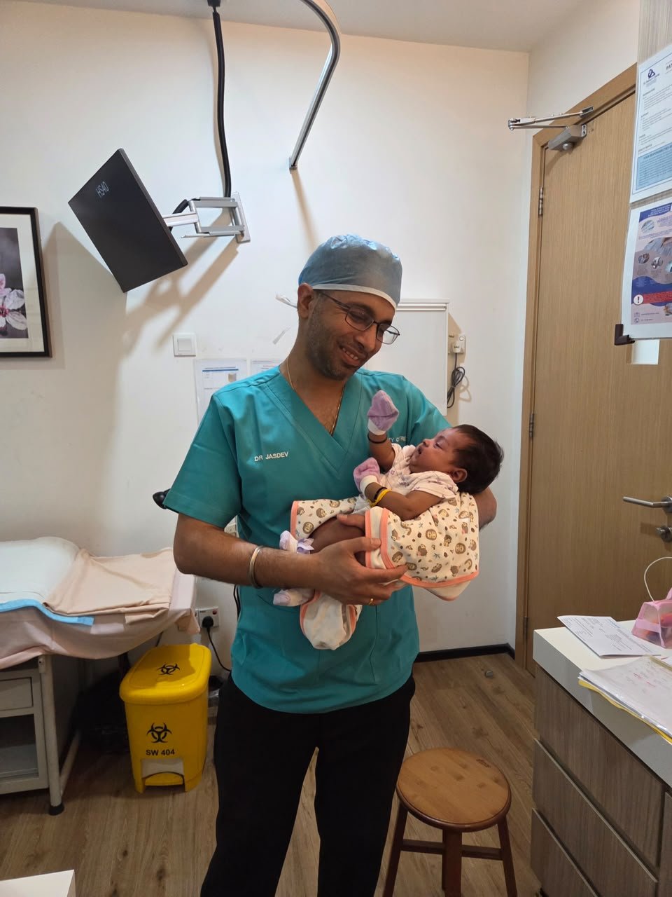 Dr Jasdev Singh holding a newborn during a clinic visit